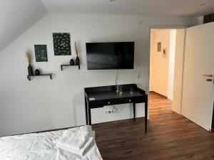 a bedroom with a desk and a television on a wall at Altes Eichamt Schweinfurt in Schweinfurt