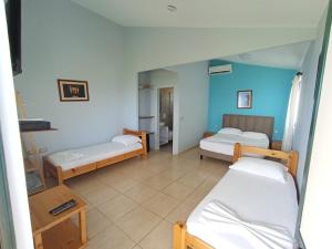 a room with three beds in a room with blue walls at Chalet Ambel in Dhërmi