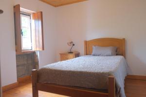 a bedroom with a bed and a window at Quinta da Cavada - Casa da Tertúlia in Vouzela