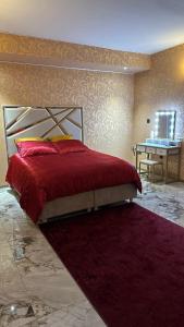 una camera da letto con un letto con un piumone rosso di Le Palais du Khalif a Fabrègues