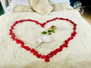 a heart made out of red roses on a bed at Saphir Spa in Amiens