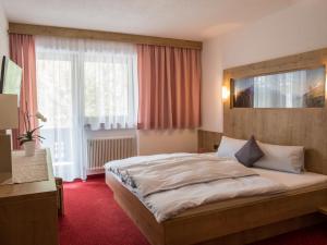 sypialnia z dużym łóżkiem i dużym oknem w obiekcie Appartement Holzknecht w Solden
