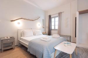 a white bedroom with a bed and a table at SWELL S6 new studio in Naousa in Naousa