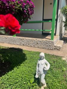 a statue of a little boy sitting in the grass at Chalet Ambel in Dhërmi