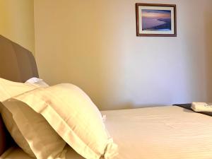 a bedroom with a bed and a picture on the wall at Chalet Ambel in Dhërmi