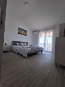 a bedroom with a large bed in a white room at Chorev Apartments in Valandovo