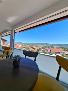 a room with a table and chairs and a large window at Chorev Apartments in Valandovo