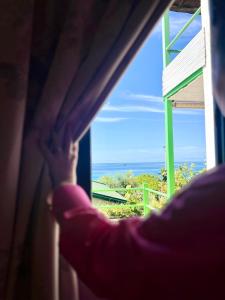 a person looking out of a window at the ocean at Chalet Ambel in Dhërmi