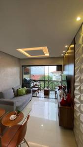 ein Wohnzimmer mit Sofa und Tisch in der Unterkunft Flat Fazenda Monte Castelo Gravatá in Bezerros