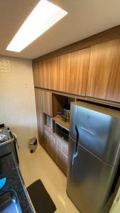 eine Küche mit Edelstahlkühlschrank und Holzschränken in der Unterkunft Flat Fazenda Monte Castelo Gravatá in Bezerros + 37 Fotos