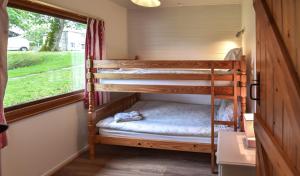 a bunk bed in a tiny house with a window at Ta Mill Cottages & Lodges - Brookview Lodge 3 in Launceston