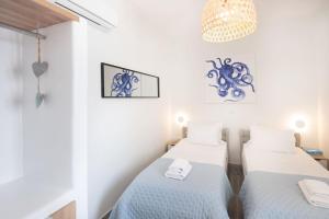 a room with two beds and a chandelier at Swell S7 new 2 bd flat in Naousa in Naousa