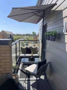 a patio with an umbrella and chairs on a balcony at Millicent Room in Littlehampton