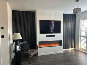 a living room with a fireplace with a tv above it at Millicent Room in Littlehampton