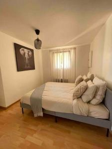 a bedroom with a bed with white sheets and pillows at Le Priest - Calme, hopital nord, fac de médecine in Saint-Priest-en-Jarez