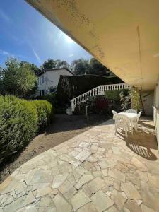 a patio with two white chairs and a white fence at Le Priest - Calme, hopital nord, fac de médecine in Saint-Priest-en-Jarez