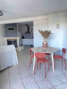 a kitchen with a table and red chairs in a room at Le Priest - Calme, hopital nord, fac de médecine in Saint-Priest-en-Jarez +6 photos
