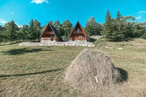 a pile of hay in front of a cabin at Domaćinstvo braća Rebić in Gacko