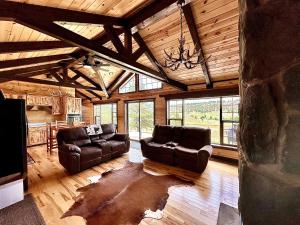 a living room with two leather couches and a table at The Lodge at Devils Tower in Devils Tower