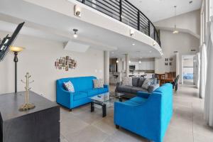 a living room with blue couches and a staircase at Bali Bay Resort in Myrtle Beach