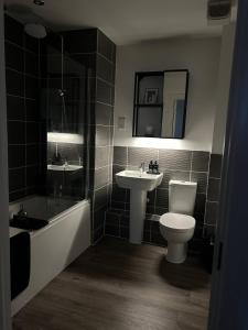 a bathroom with a sink and a toilet and a bath tub at Millicent Room in Littlehampton
