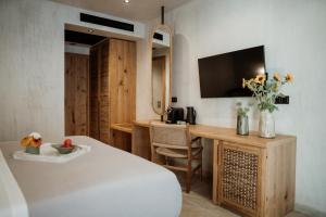 a bedroom with a bed and a desk with a television at Kalani Residence in Keramoti