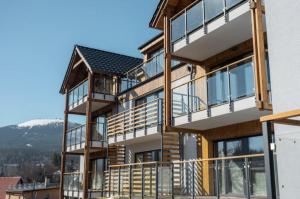 a house with balconies and a mountain in the background at SUNN Aparthotel Szklarska Poręba in Szklarska Poręba