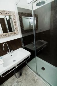 ein Bad mit einem Waschbecken und einer Glasdusche in der Unterkunft A Casa di Lu Na in Bologna
