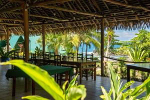 a restaurant with tables and chairs and a view of the ocean at Corcovado Adventures in Drake