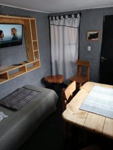 a bedroom with a bed and a table and a chair at Tierras Mágicas in Villa Pehuenia
