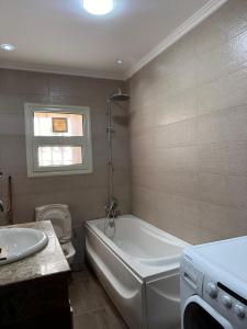 a bathroom with a tub and a toilet and a sink at الخمايل الشيخ زايد in Kafr Abū ʼumaydah