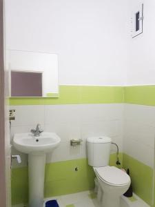 a bathroom with a white toilet and a sink at Appartement des vacances à Bades près de corniche in Al Hoceïma