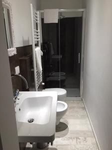 a bathroom with a white sink and a toilet at A Casa di Lu Na in Bologna