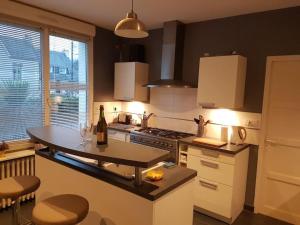 a kitchen with a table with a bottle of wine at Le Chalet de l'Odet in Quimper