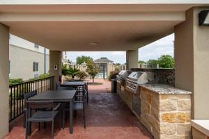 a patio with a grill and tables and chairs at Candlewood Suites Deer Park by IHG in Deer Park