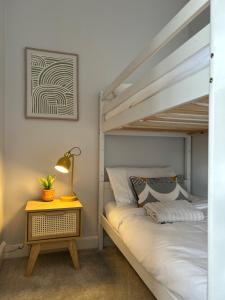 a bedroom with a bunk bed with a lamp and a side table at Cosy flat in Alnwick in Alnwick