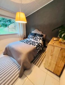 Un dormitorio con una cama y una ventana grande. en Casinha Branca da Cascata, Lumiar, en Lumiar