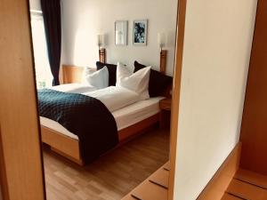 a bedroom with a bed and a mirror at Am Landhaus - Gästezimmer in Walsheim
