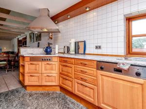a kitchen with wooden cabinets and a sink at 8 person holiday home in Hadsund-By Traum in Hadsund