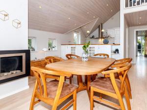 a kitchen and dining room with a wooden table and chairs at 5 star holiday home in Hadsund-By Traum in Hadsund