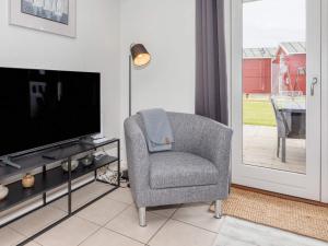 a living room with a chair and a television at 6 person holiday home in Hadsund-By Traum in Hadsund