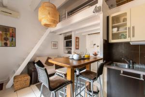 Una cocina con una mesa y sillas en una habitación. en L'Intimate Sahara - Piscine - Tennis - Clim, en Cap d'Agde