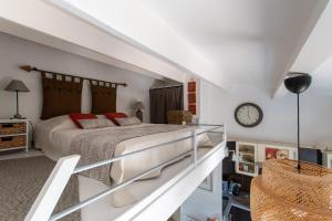 Un dormitorio con una cama y un reloj en la pared. en L'Intimate Sahara - Piscine - Tennis - Clim, en Cap d'Agde