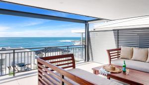 a balcony with a couch and a view of the ocean at The Palms Yamba - Overlooking Convent Beach in Yamba