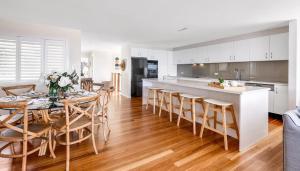 a kitchen and dining room with a table and chairs at The Palms Yamba - Overlooking Convent Beach in Yamba