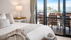 a bedroom with a bed with a view of the ocean at The Palms Yamba - Overlooking Convent Beach in Yamba