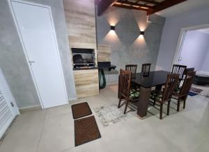 a dining room with a black table and chairs at Casa Nova Marilea in Rio das Ostras