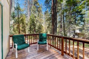two chairs on a deck with trees in the background at Fire Pit, Near Lake: 'Evergreen Escape' in Arnold in Arnold