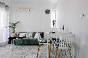 a living room with a table and chairs and a couch at Stadium Apt in Kos
