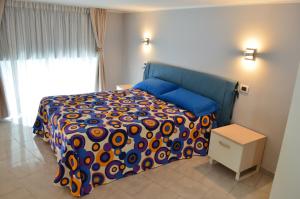 a bedroom with a bed with a colorful comforter at Appartamenti Piazza Duomo Acireale in Acireale